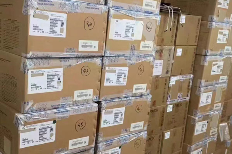a large stack of boxes on pallets inside a warehouse, organized for storage and distribution